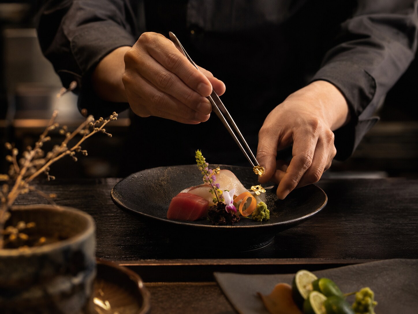 料理人が箸先で一皿を仕上げる手元
